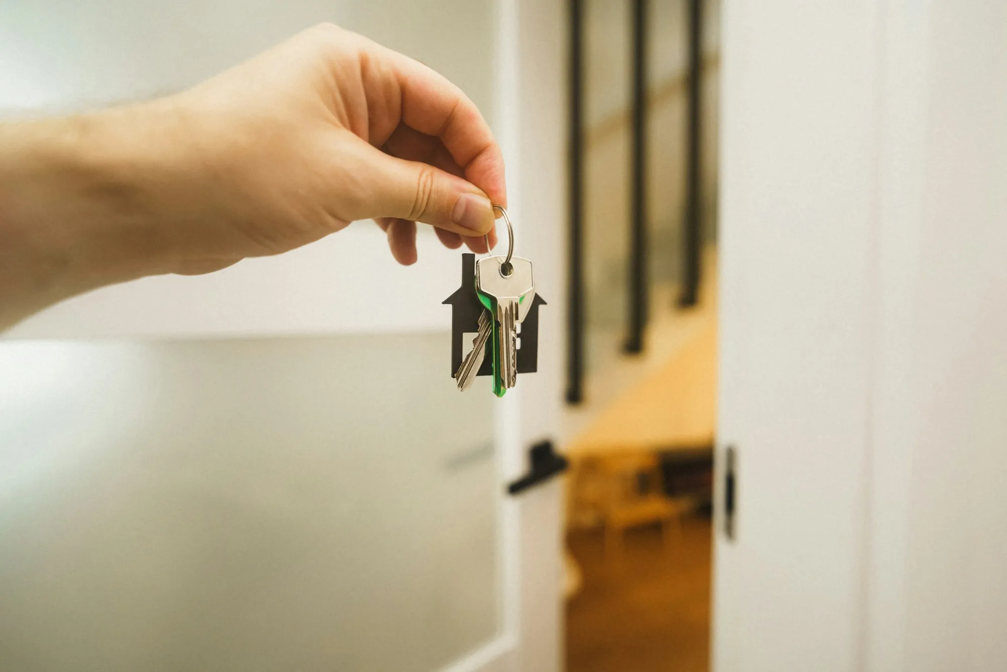 Hand holding house keys inside a new home
