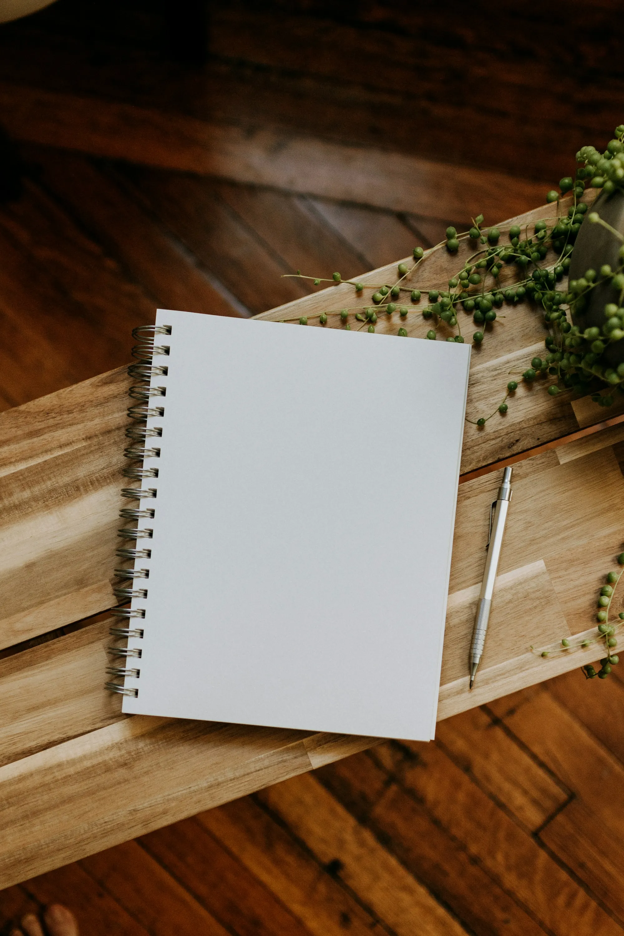 Spiral notebook and pen on a wooden desk