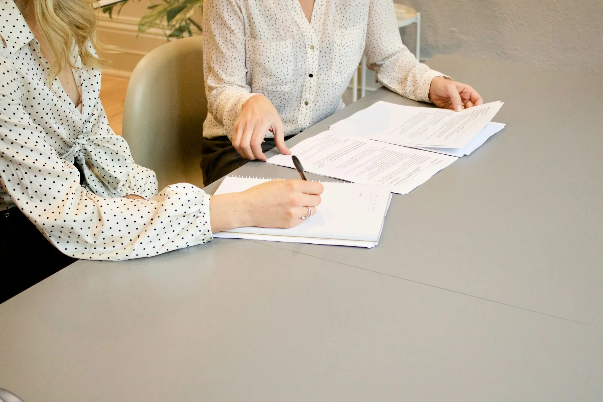 Two people reviewing paperwork at a white table