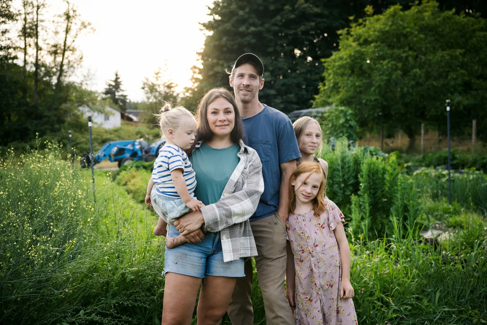 Family of five standing together in tall grass