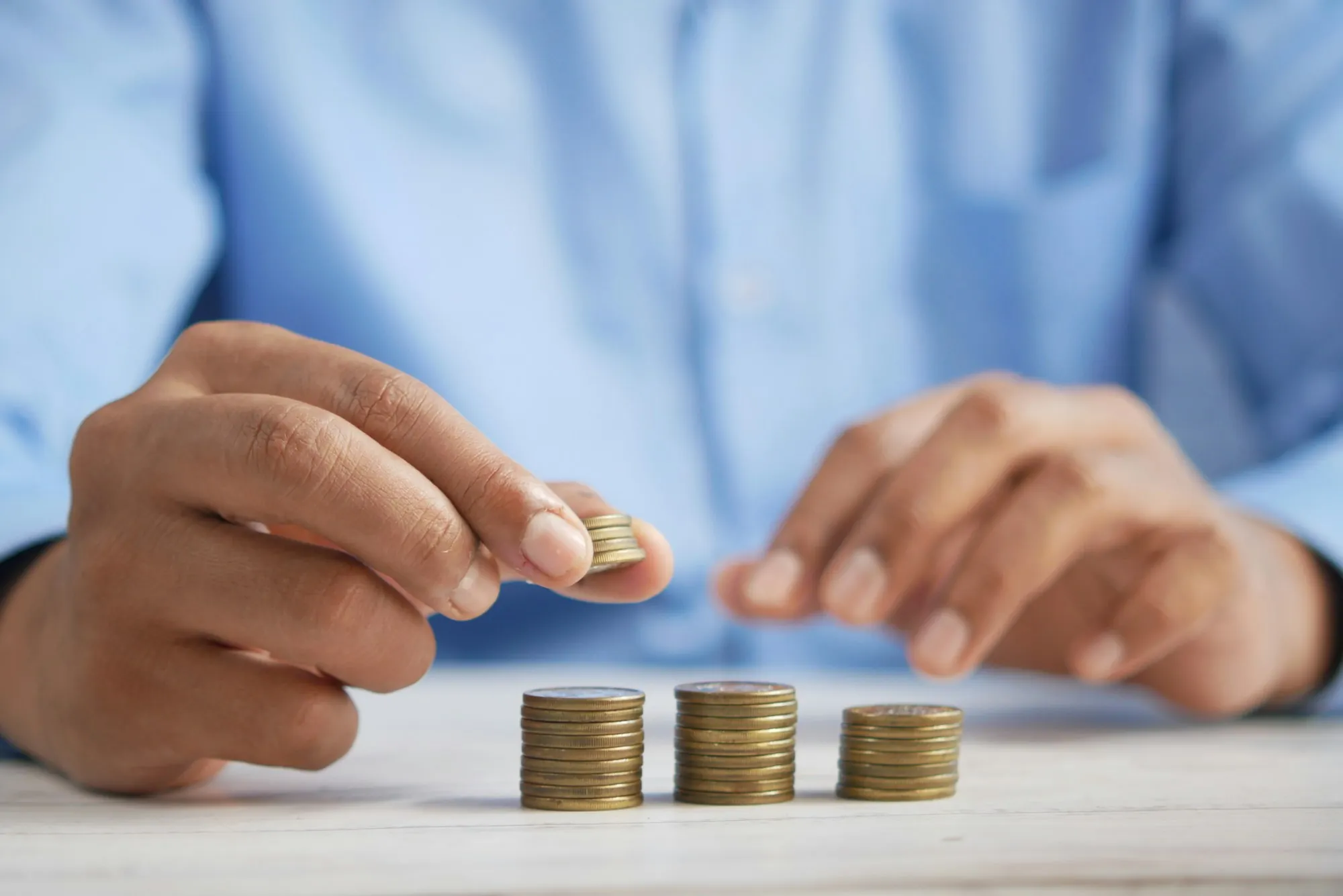 Hands stacking coins on a table