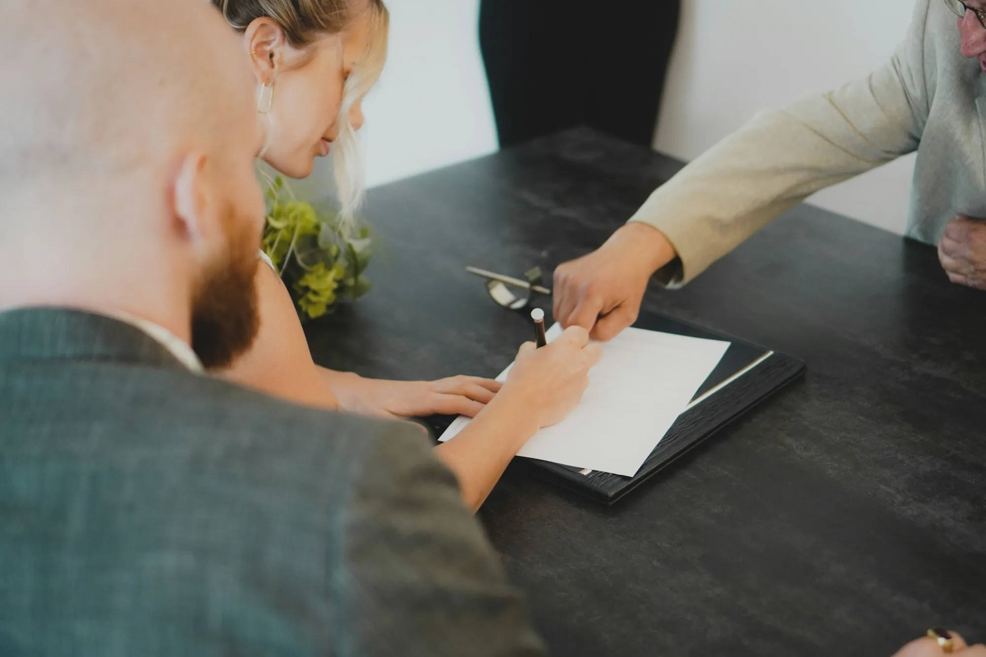 Two people reviewing forms across a dark table, sorting out what happens when term life insurance expires, in Buffalo Grove